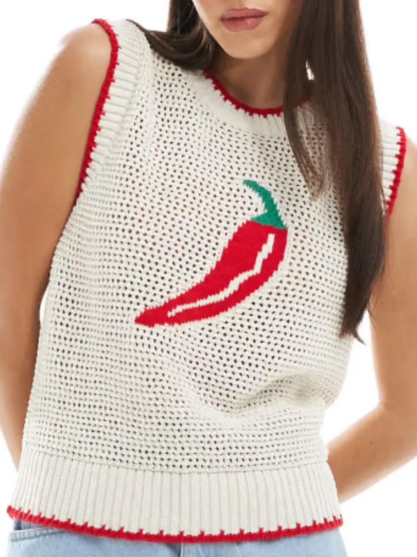 Woman wearing a white sleeveless crochet top with a red chili pepper design on a white background