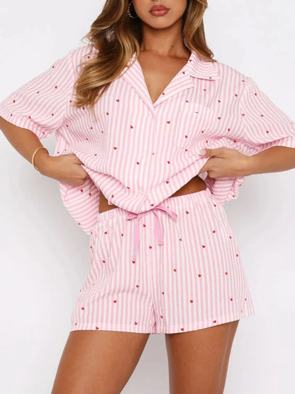 Woman wearing a pink and white striped pajama set with a white background