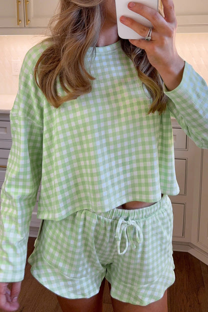 Person wearing a green and white checkered outfit in a kitchen.