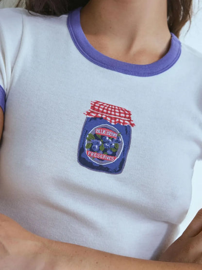 lavender ringer baby tee with vintage-style blueberry preserves print on the front.