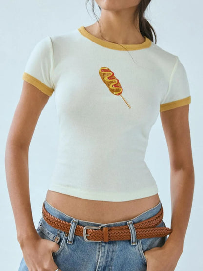 White and mustard yellow ringer baby tee featuring a printed corndog graphic on the chest.
