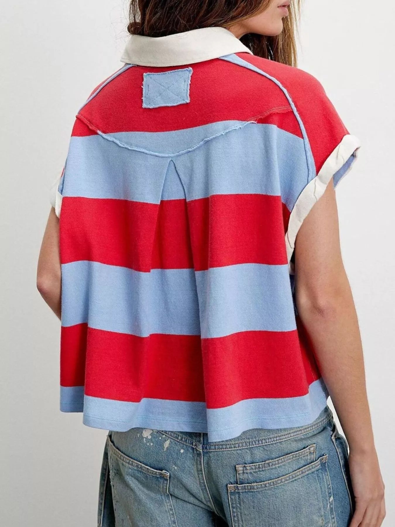 Red and blue striped shirt worn by a person on a plain background