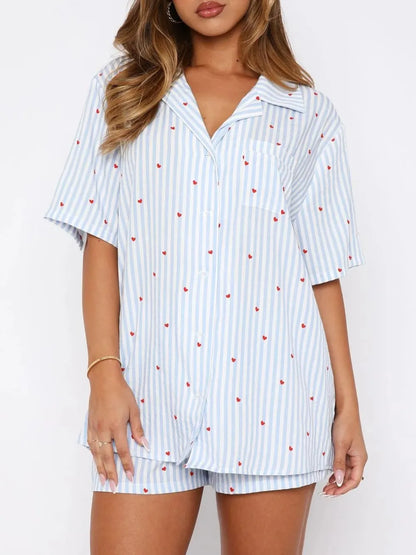 Woman wearing a light blue striped pajama set with red hearts on a white background