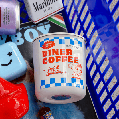 Candle labeled 'Diner Coffee' with various items on a textured surface
