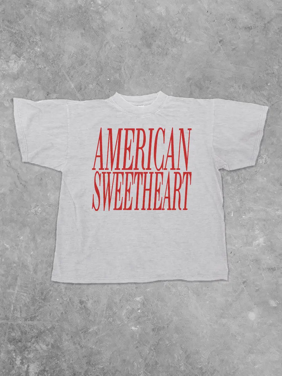 White t-shirt with 'AMERICAN SWEETHEART' in red text on a gray concrete background