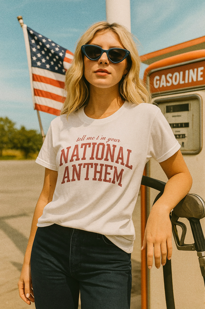 Girl wearing "Tell Me I'm Your National Anthem" tee at desert gas station in vintage Americana aesthetic